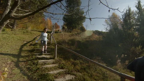 Confident young couple jogging down the stairs in autumn. Side view shot. Sun Stock Footage 166155943