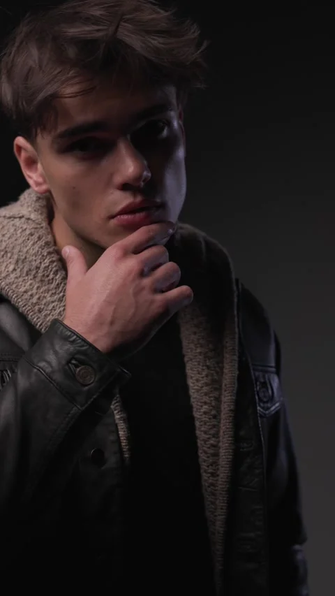 Confident young guy in his twenties looking forward, touching chin and thinking, Stock Footage 300385643