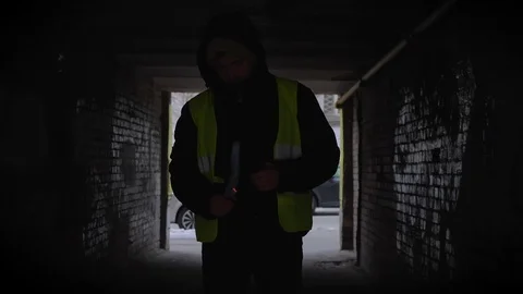 Confident young guy standing in a dark alley with a burning Molotov cocktail Stock Footage 99477269