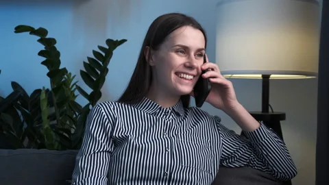 Confident young lady spend time in pleasant phone conversation sit on couch Stock Footage 226528277