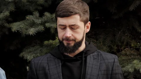 Confident young man with beard talks with friends in park Stock Footage 285396202