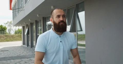 Confident young man in light polo on a summer day rides a scooter to the office Stock Footage 115940477