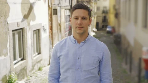 Confident young man posing on old city street background Stock Footage 108820650