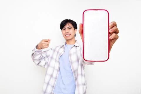 Confident young man smiling while presenting a smartphone with a blank scre.. Stock Photos