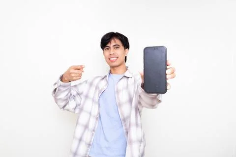 Confident young man smiling while presenting a smartphone with a blank scre.. Stock Photos