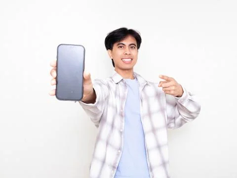 Confident young man smiling while presenting a smartphone with a blank scre.. Stock Photos