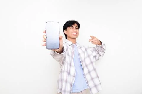 Confident young man smiling while presenting a smartphone with a blank scre.. Stock Photos