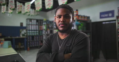 Confident young man standing with arms crossed in a paint store, representing pr Stock Footage 318743830