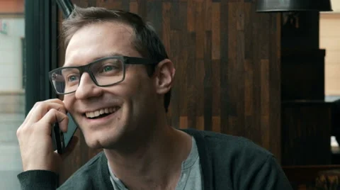 Confident young man talking on the mobile phone and smiling, indoors. 動画素材 61323592