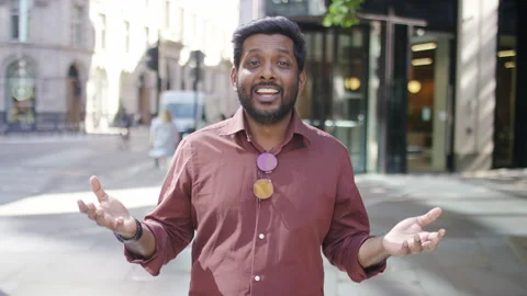 Confident young presenter on the streets talking to camera as he walks Stock Footage 249710433