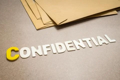 Confidential wording on brown background Stock Photos