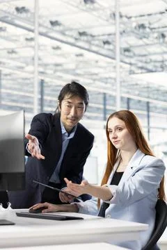 Configuring PCB electronic hardware setups, tablet and manager teaching girl Stock Photos