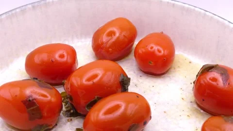 Confit cherry tomatoes in olive oil rotating on white 스톡 동영상 344054065