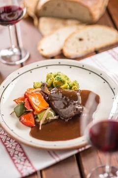 Confit rabbit leg with vegetable bread redvine in pub or restaurant Stock Photos