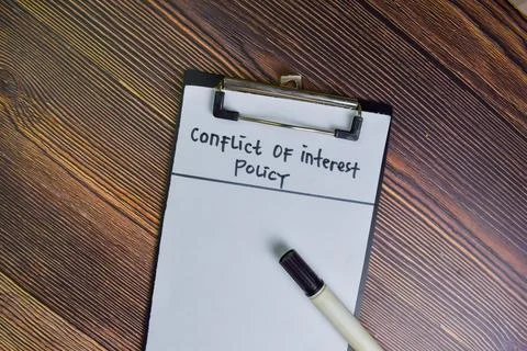 Conflict of Interest write on a paperwork isolated on Wooden Table. Stock Photos