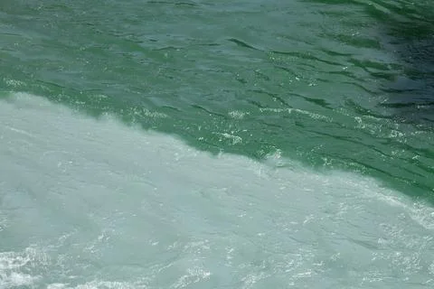Confluence of two rivers of different colors. Green flowing water Stock Photos