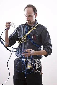 CONFUSE TECHNICIAN Computer technician in full cable gear laughing ,model ... Stock Photos