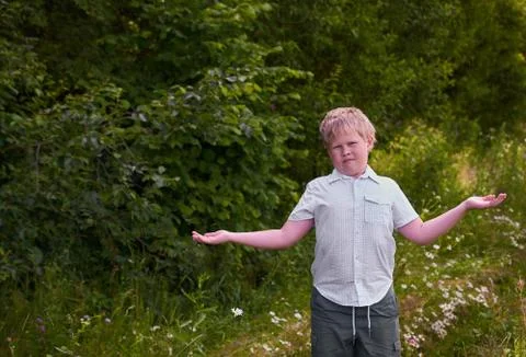 A confused boy throws up his hands on a walk in the Park Stock Photos