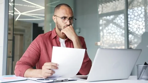 Confused businessman having difficulty with paperwork checking documents  Stock Footage 311622331