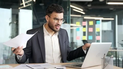 Confused businessman having difficulty with paperwork checking documents  Video stock 319777248