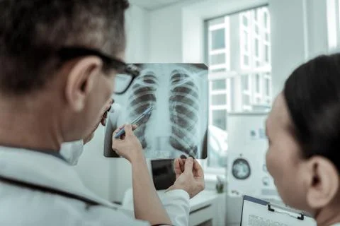 Confused doctors attentively looking on the bone structure Stock Photos