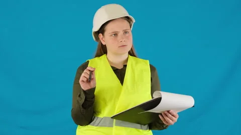 Confused engineer in work vest and helmet examines object Stock Footage 316106275