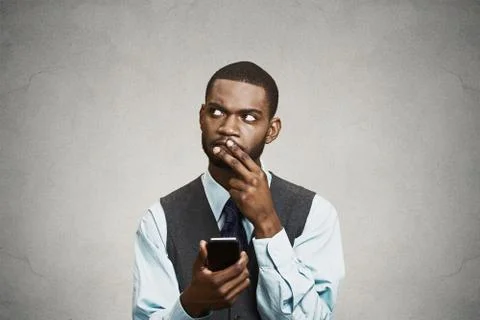 Confused executive thinking how to reply to message on smart phone Stock Photos