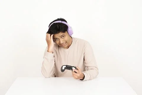 Confused gamer with controller having technical problems Stock-Fotos