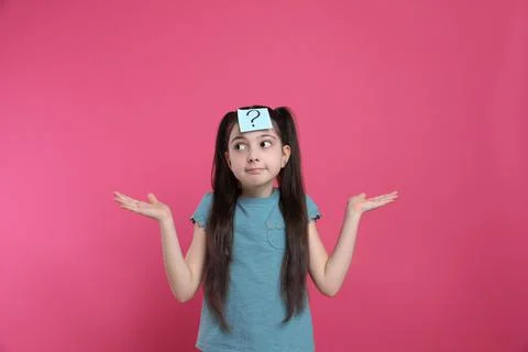 Confused girl with question mark sticker on forehead against pink background Stock Photos