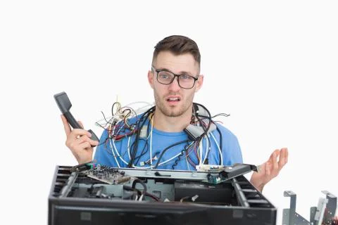 Confused it professional with cables and phone in front of open cpu Stock Photos