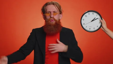 Confused man with anxiety checking time on clock, running late to work, being in Stock Footage 218759864