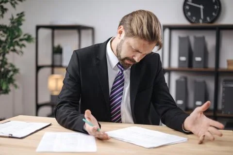 Confused manager checking documents at office Stock Photos