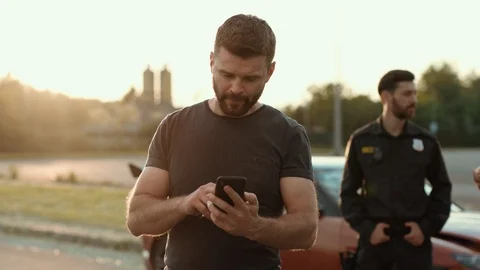 Confused middle-aged man in trouble using a smartphone outdoors. Male driver Stock Footage 112988456