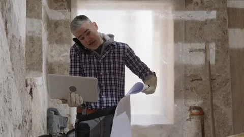 Confused puzzled construction builder worker on a renovation building site .. Stock Footage 307842203