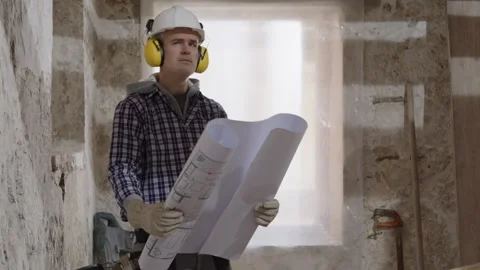 Confused puzzled construction builder worker at a renovation building site .. Stock Footage 307843361