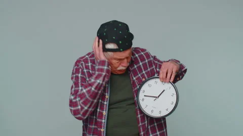 Confused senior man with anxiety checking time on clock running late to work Stock Footage 190843217