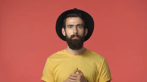 Confused serious-looking middle-eastern guy with long beard in black hat, yellow Stock Footage 115779874