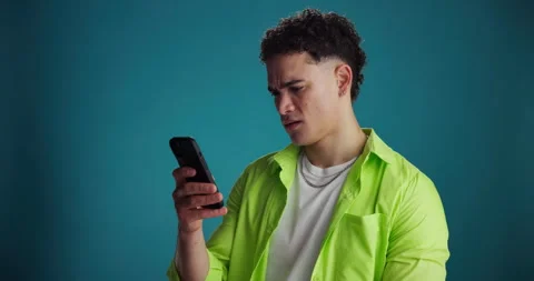 Confused, smartphone and man in studio, online reading and frustrated with email Stock Footage 314039636