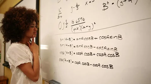 Confused student looking at maths on whiteboard Stock Footage 36053485