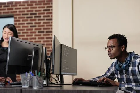 Confused tech engineer sitting doubtful at computer trying to solve network 写真素材