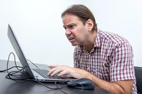 The confused unhappy user is looking at the computer screen. Stock Photos