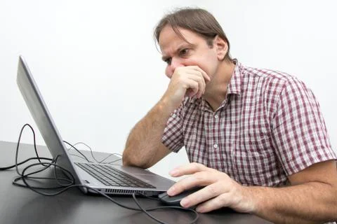 The confused unhappy user is looking at the computer screen. 스톡 사진
