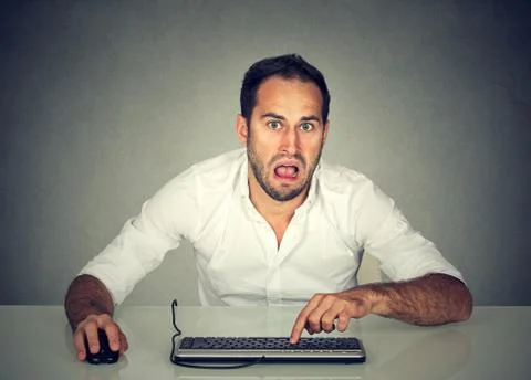 Confused upset young man working on computer Stock Photos