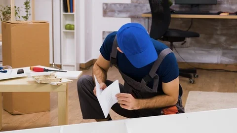 Confused worker in overalls reading instructions Stock Footage 123298134