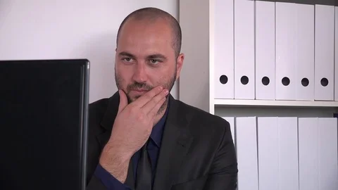 Confused worried young corporate office worker reading computer rubbing his chin Stock Footage