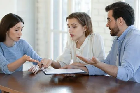 Confused young couple dissatisfied with contract terms of conditions. Stock Photos