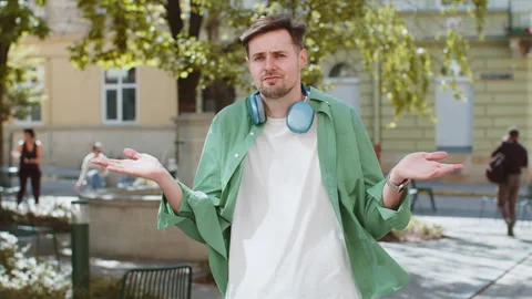 Confused young man feeling embarrassed about ambiguous question having doubts no Stock Footage 277175478
