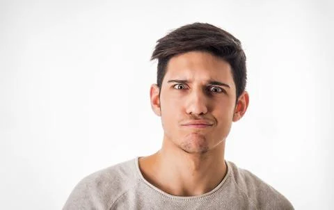 Confused young man looking at camera in studio Stock Photos