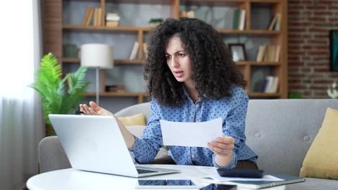 Confused young woman having difficulty doing household finances using  库存影片 330659260