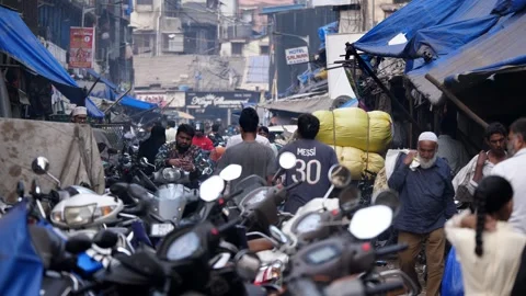 Congested Indian narrow lane with bikes parked and people walking, Mumbai Stock Footage 329098633